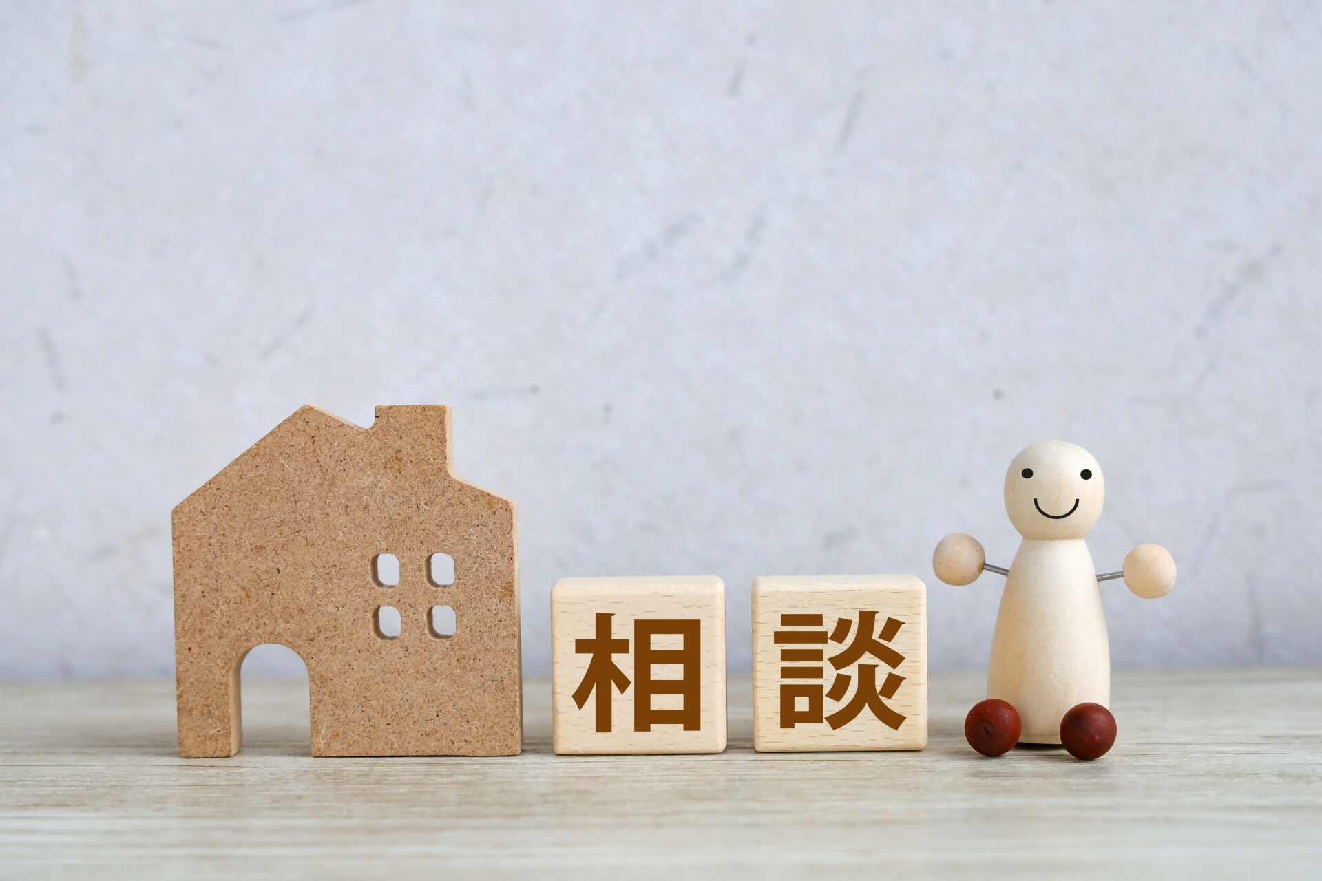 戸塚区で不動産売却の相談をするイメージ（家の模型と相談の文字）
