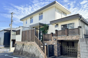 高台に位置するゆとりある敷地の中古戸建外観（駐車スペース付き）