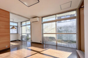 大きな窓から光が差し込む開放的なリビングと広々とした室内空間