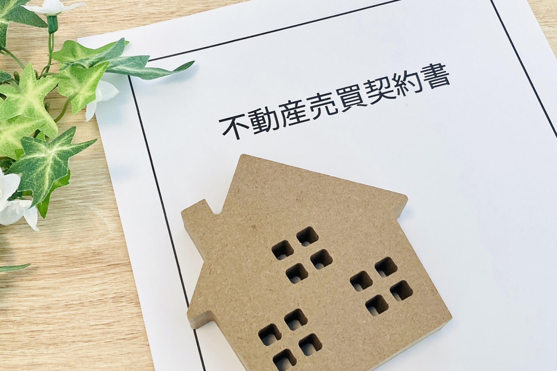 不動産売買契約書と住宅模型のイメージ
