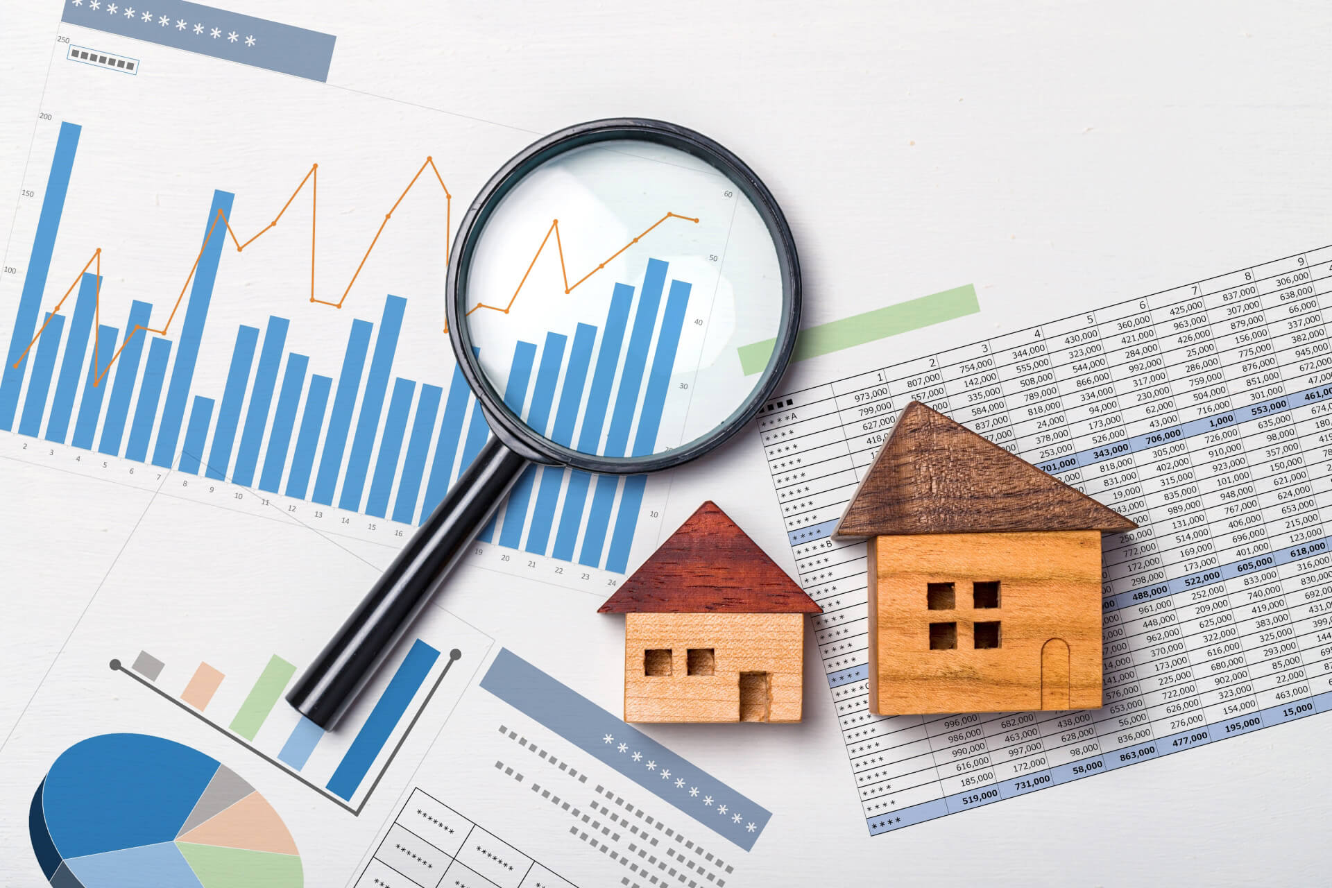 住宅模型とグラフを確認する虫眼鏡｜不動産査定額と売り出し価格を検討するイメージ