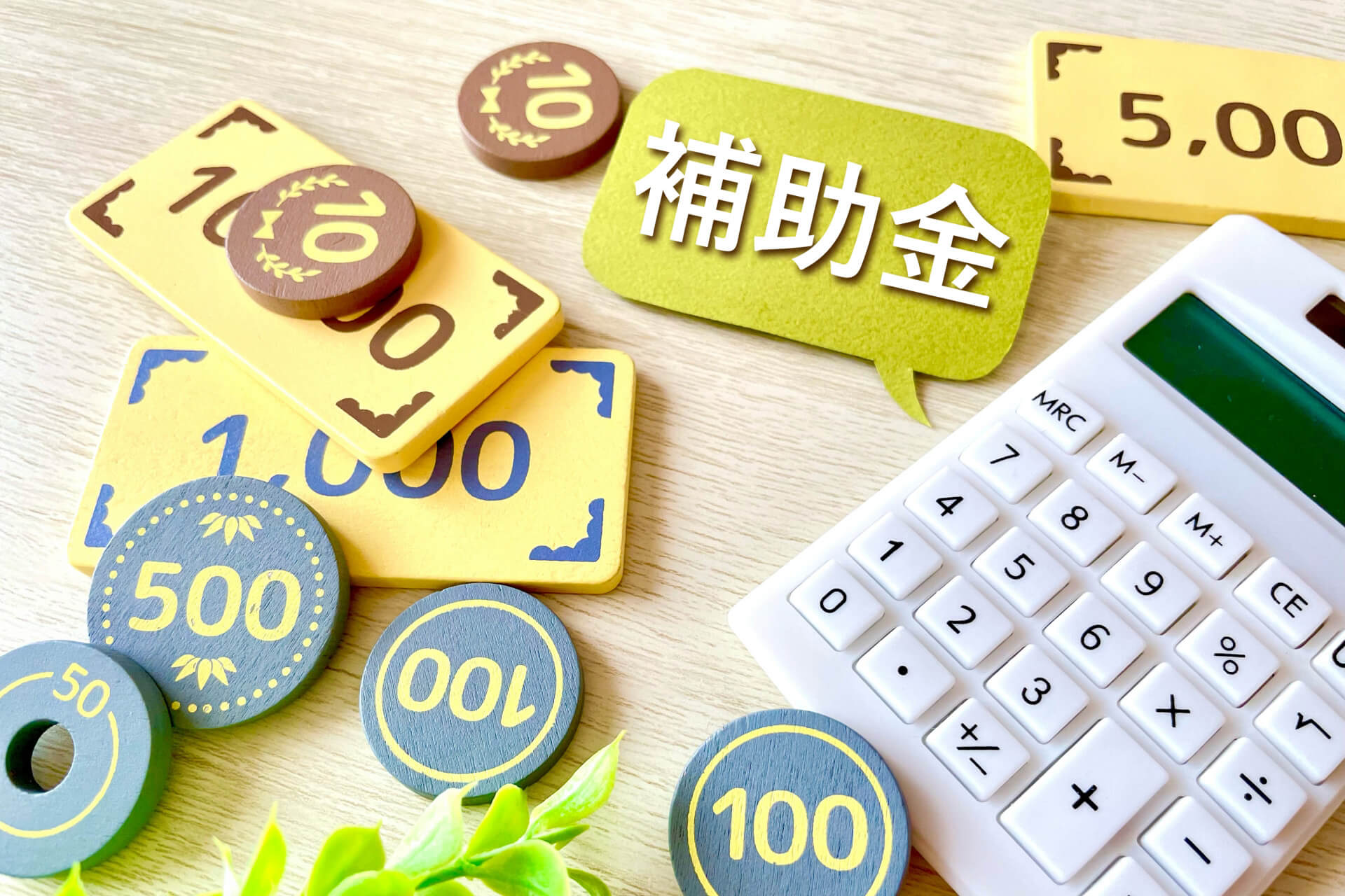 「補助金」と書かれた吹き出しとお金、電卓｜空き家処分の費用や補助金を表すイメージ