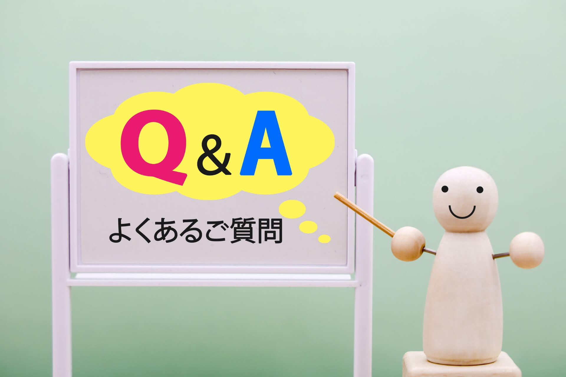 「Q&A よくあるご質問」と書かれたボードを案内する人形｜横浜の土地購入に関するよくある質問のイメージ