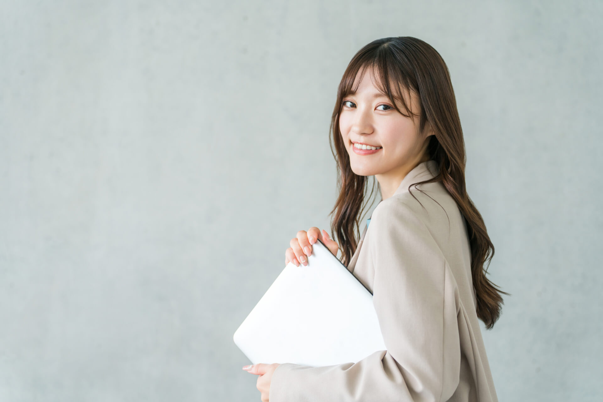 書類を持って微笑む女性｜不動産売却の相談をサポートするイメージ